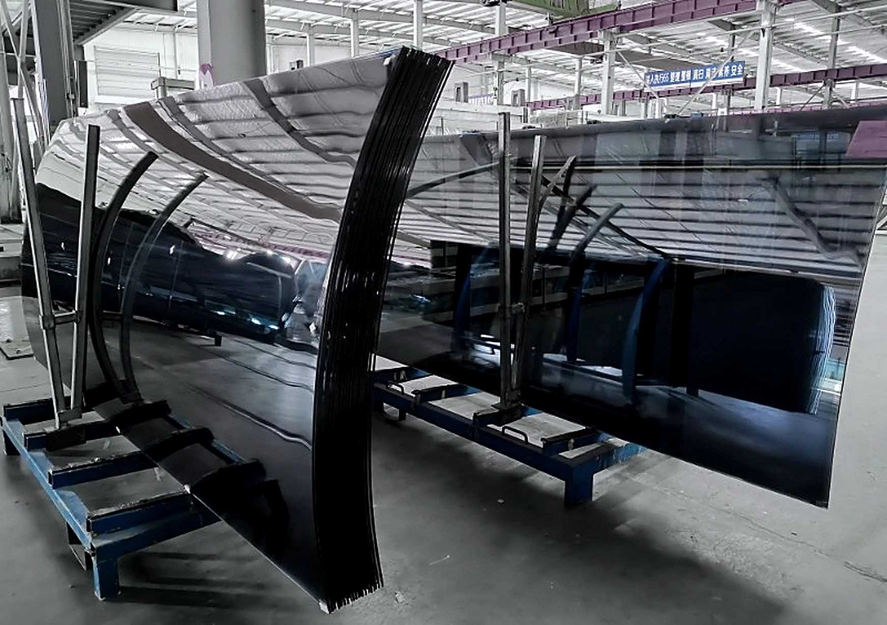 Bent glass panels on transport frames in the works environment